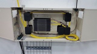 Gabinete mural con equipos y cableado de fibra óptica